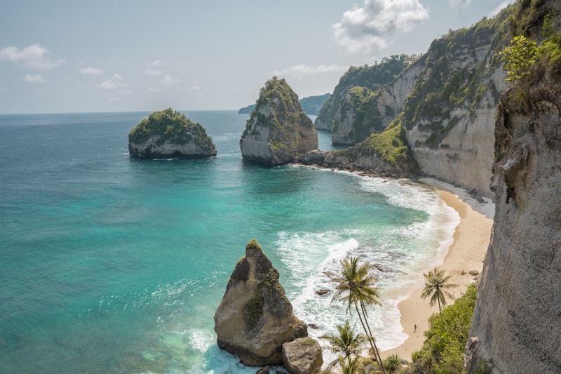 Turquoise Caribbean bay with tropical cliffs and palm trees